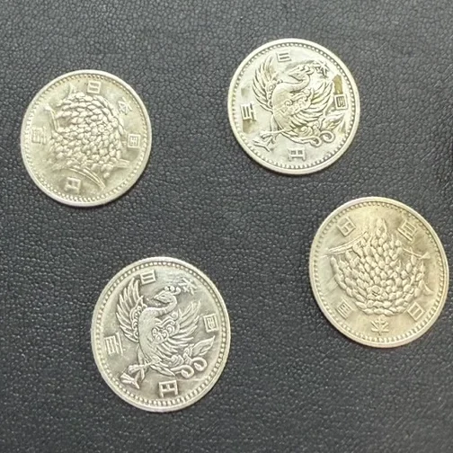 稲穂と鳳凰の図柄がある100円銀貨を各2枚、計4枚並べた写真