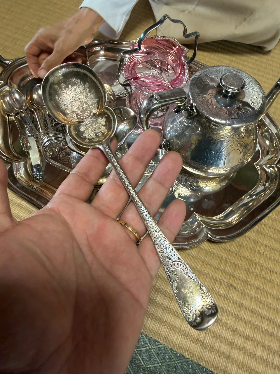 花の模様があるすくう部分と、細かな装飾が続く長い柄を備えた銀の道具
